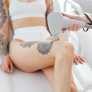 Cosmetologist performing laser hair removal procedure in beauty salon